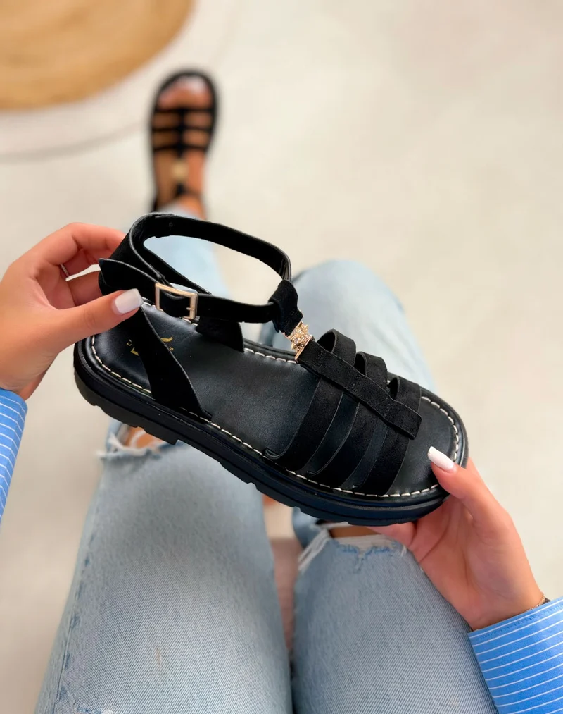 Sandales femme noires tendance en suédine avec semelle crantée et bijou soleil doré