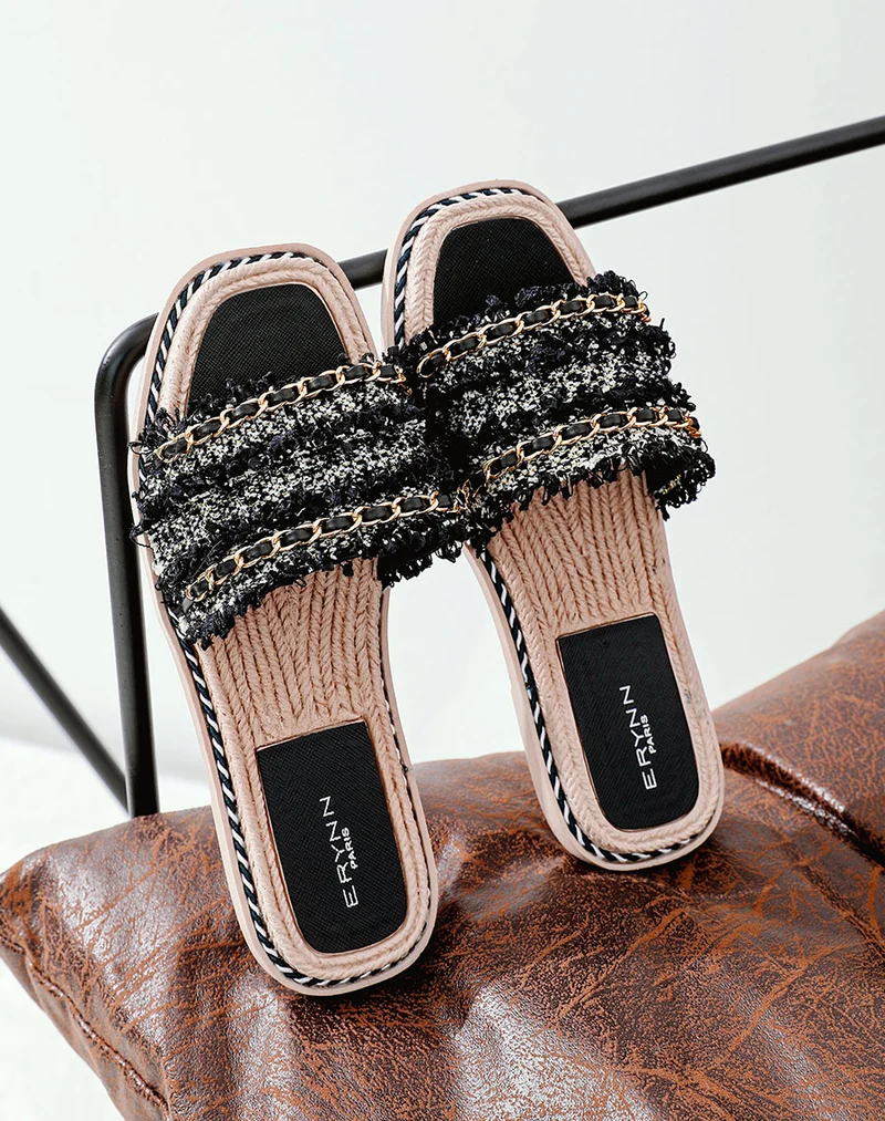 Mules plates noires à multiples détails et fine chaîne dorée